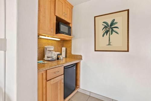 a small kitchen with a sink and a microwave at Aston Maui Kaanapali Villas in Lahaina