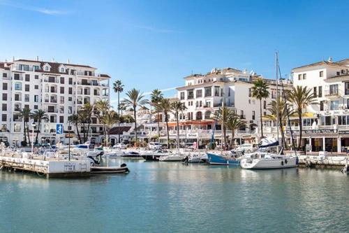 a group of boats docked in a marina with buildings at Spacious duplex apartment families and couples in Manilva