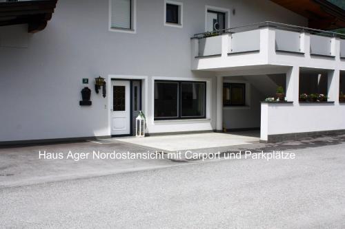 a white building with a balcony on the side at Ferienwohnung Apartment Haus Ager in Thiersee