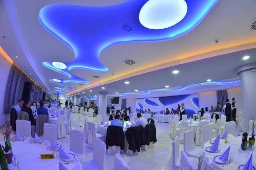a large banquet hall with white tables and white chairs at Vazdušna Banja in Niš