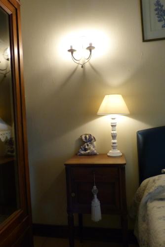 une lampe sur une table à côté d'un lit dans l'établissement Domaine de la Mouthe, à Saint-Rémy