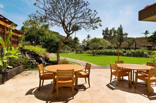 a patio with two tables and chairs and a park at Aston Maui Kaanapali Villas in Lahaina