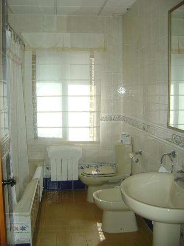 a bathroom with two toilets and a sink and a tub at Hotel Rural Puerto Mágina in Torres