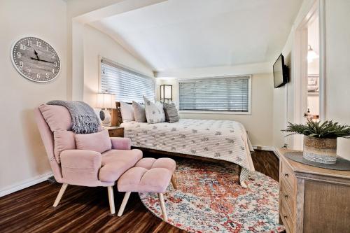 - une chambre avec un lit, une chaise et un réveil dans l'établissement Sara's Cottage, à Eureka Springs