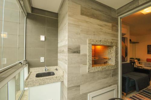 a bathroom with a sink and a fireplace at Thai Beach Home Spa: Apto 200m da Praia N605 in Florianópolis