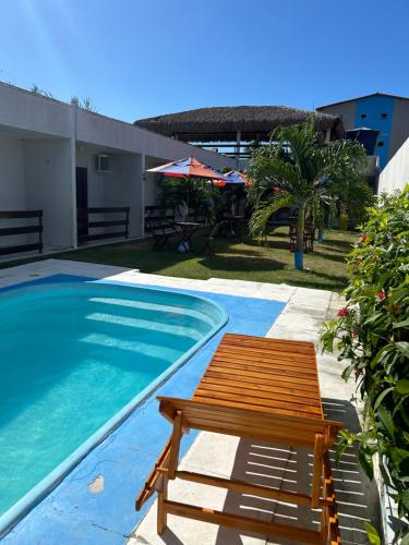 un banc en bois à côté d'une piscine dans l'établissement Pousada Lagoa Azul, à Caucaia