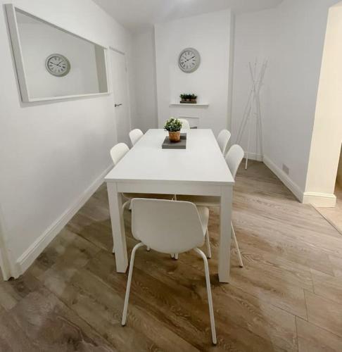 a white dining room with a white table and chairs at Rodney Road in Great Yarmouth