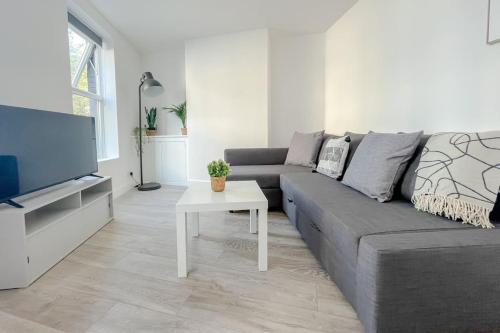 a living room with a gray couch and a table at Rodney Road in Great Yarmouth