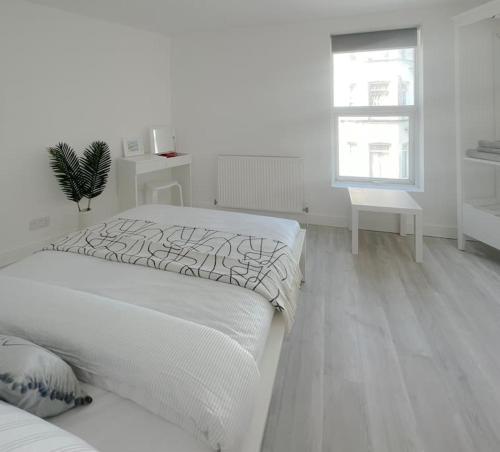 a white bedroom with a bed and a window at Rodney Road in Great Yarmouth