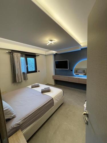 a bedroom with a bed and a flat screen tv at sailors apartments Perigiali in Nydri