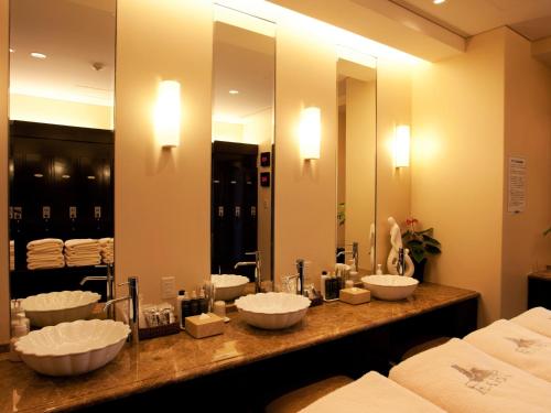 a bathroom with four sinks in front of a mirror at Okinawa Kariyushi Resort EXES Onna in Onna