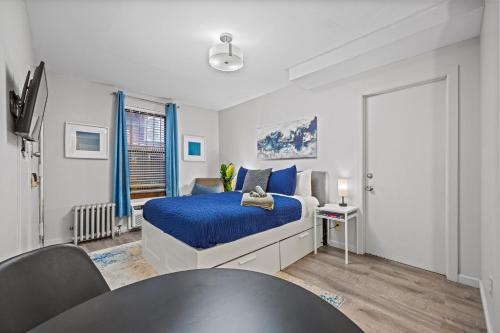 a bedroom with a king sized bed with blue sheets at Highly Recommended Studio Near Times Square in New York