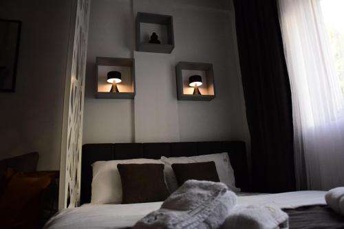 a bedroom with a bed with two lights on the wall at Apartman Suny N58 in Kopaonik