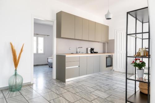 a kitchen with white cabinets and a tile floor at Sterna House Alkistis in Parikia
