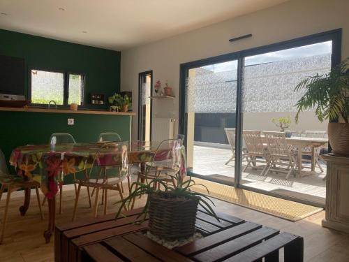 d'un salon avec une table et des chaises ainsi que d'une terrasse. dans l'établissement Maison plain-pied - Guidel, à Guidel