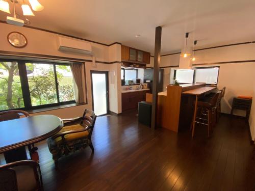 a living room with a table and a kitchen at 高野山 こころの寺子屋リトリートハウス -Koyasan Retreat House IKKOSHO in Koyasan