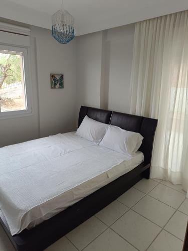 a large bed in a bedroom with a window at Olive & Garden in Nea Moudania