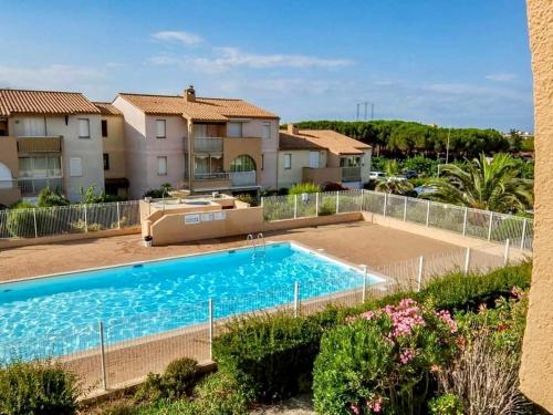 une grande piscine devant une maison dans l'établissement Bel appartement avec terrasse, au Cap d'Agde