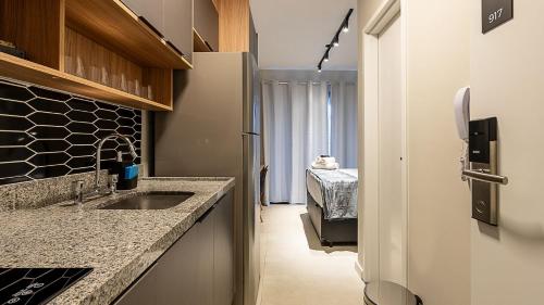 a small kitchen with a sink and a refrigerator at Studios modernos e completos ao lado da estação Vila Mariana in Sao Paulo