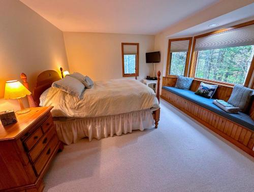 a bedroom with a bed and a couch at Bretton Woods home steps from the slopes, AC, pool passes, discounted cog tix! in Bretton Woods