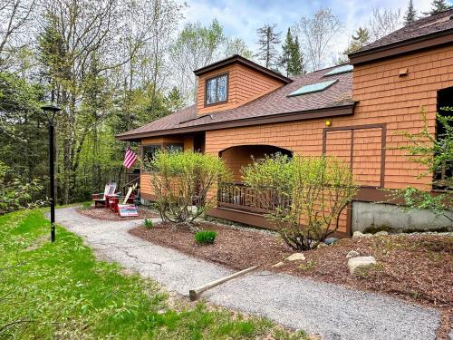 a house with a flag on the side of it at Bretton Woods home steps from the slopes, AC, pool passes, discounted cog tix! in Bretton Woods