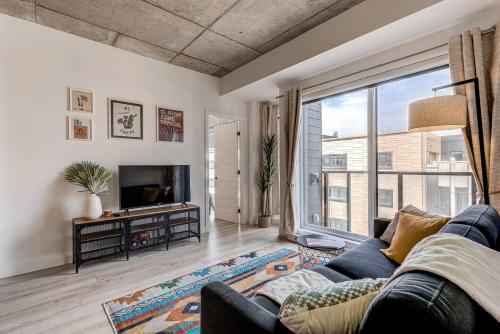 a living room with a couch and a large window at El Chico in Quebec City