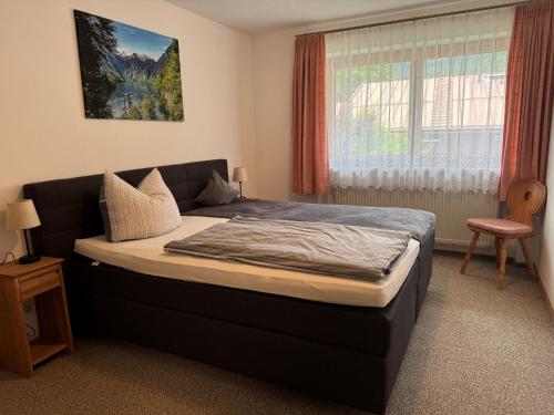 une chambre avec un lit dans une pièce avec une fenêtre dans l'établissement Ferienwohnungen Artenreitwinkl Hallinger, à Schönau am Königssee