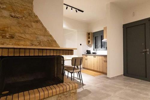 a living room with a fireplace and a kitchen at VASILAS Luxury Rooms & Suites in Agios Georgios