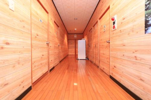 un couloir avec des murs en bois et une porte blanche dans l'établissement Miyanouraso, à Yakushima
