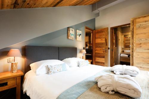 une chambre avec un grand lit avec des serviettes dessus dans l'établissement Résidence Les Arcs 1950 Le Village - maeva Home - Appartement chaleureux 3 pièces 4 personnes - Exclusive - super Home MAE-6911, à Arc 1950