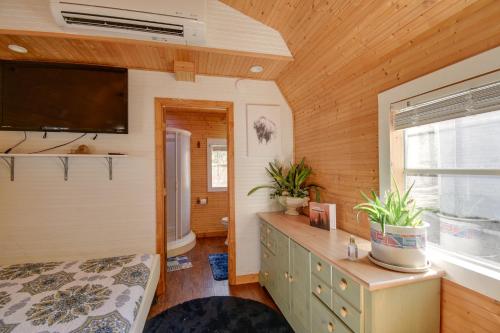 a bedroom in a tiny house with a bed and a window at Cozy Calabash Studio about 4 Mi to Sunset Beach! in Calabash