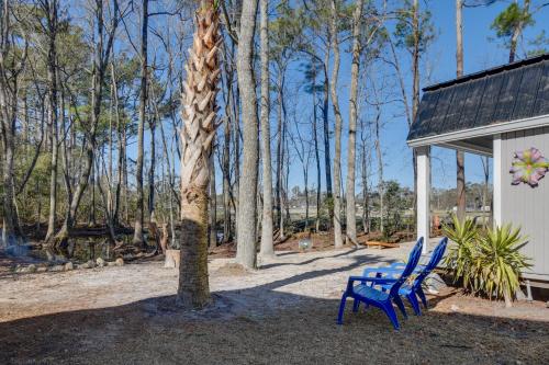 a blue bench sitting next to a tree next to a building at Cozy Calabash Studio about 4 Mi to Sunset Beach! in Calabash