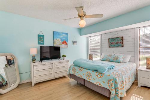 a bedroom with a bed and a flat screen tv at Lovely Retreat Walk to Manasota Key Beach! in Englewood