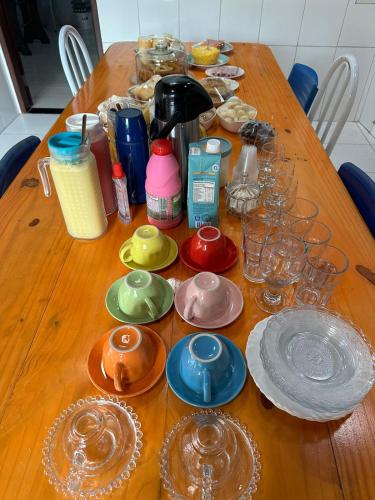een houten tafel met borden en glazen erop bij Pousadinha do seu Manoel in Barreirinhas
