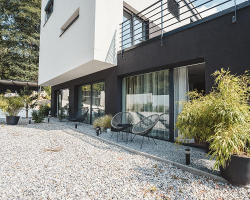 a house with black walls and windows and plants at Villa Gall in Český Krumlov