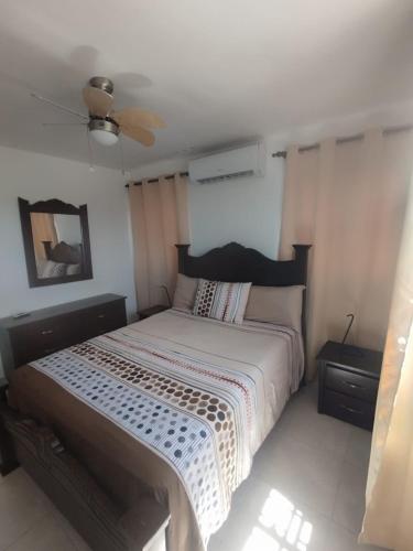 a bedroom with a bed and a ceiling fan at Caleta in La Romana