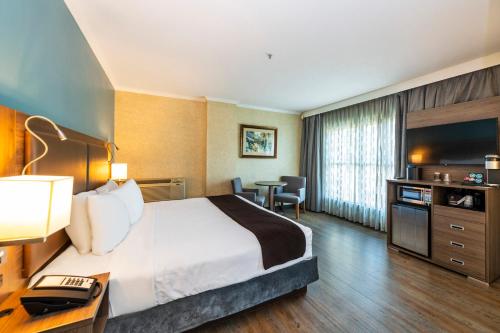 a hotel room with a bed and a desk with a telephone at Grand Park Hotel & Suites Downtown Vancouver, an Ascend Collection Hotel in Vancouver
