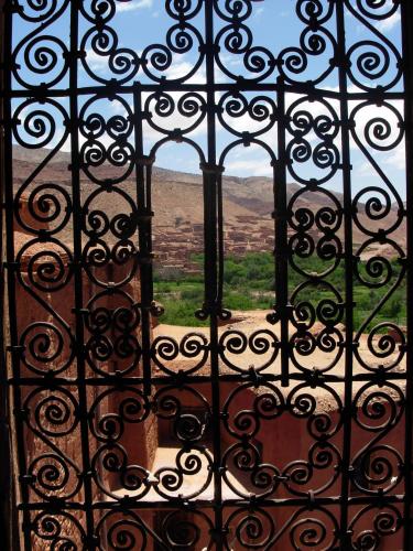 an open window with a view of a field through a gate at Kasbah Tigmi N'Oufella in Telouet