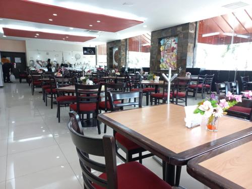 a dining room with wooden tables and chairs at Paris FC Hotel in Poza Rica de Hidalgo