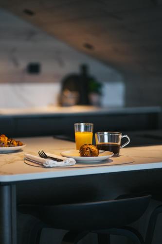 a table with two cups of orange juice and plates of food at Steam Pier Adventure Hotel in Kvaløya