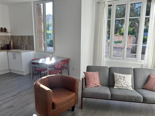 - un salon avec un canapé, une chaise et une table dans l'établissement T3 climatisé vue rade et Mont Faron, calme à la Corniche, à Toulon
