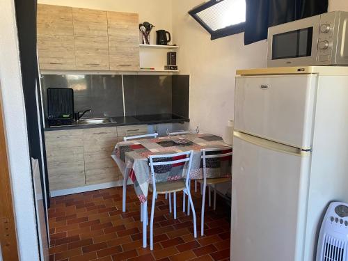 une petite cuisine avec une table et un réfrigérateur dans l'établissement Studio, au Barcarès