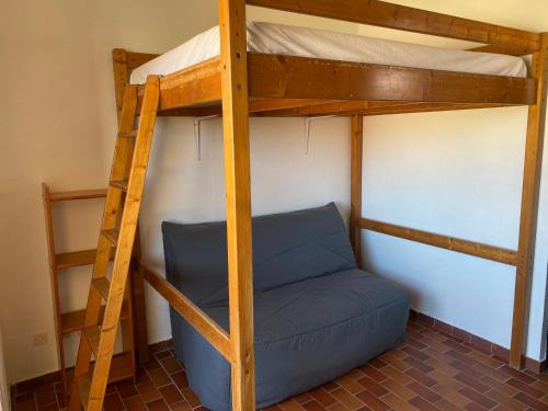 - un lit superposé avec un canapé bleu dans une chambre dans l'établissement Studio, au Barcarès