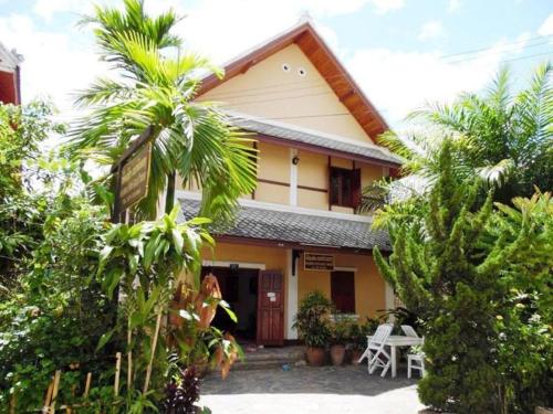 a woman standing in front of a house at Golden Lotus Place in Luang Prabang