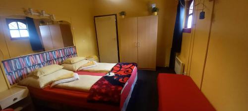 a small bedroom with two beds and a window at Táltos Vendégház in Szilvásvárad