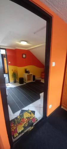 a mirror reflection of a room with an orange wall at Táltos Vendégház in Szilvásvárad