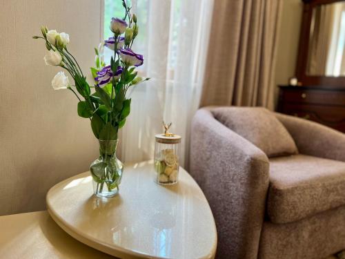 a vase of flowers on a table next to a chair at Rancho on Sevan beach by HV in Sevan
