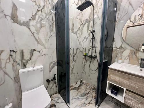 a bathroom with a shower and a toilet and a sink at Rancho on Sevan beach by HV in Sevan