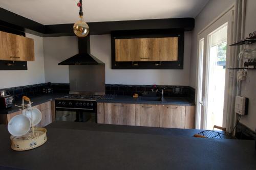 - une cuisine avec des comptoirs noirs et une cuisinière dans l'établissement Le Logis d'Aude, à Carcassonne