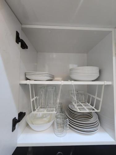 a white cabinet with plates and dishes in it at Firstwood Chic Apartment Hivernage in Marrakech